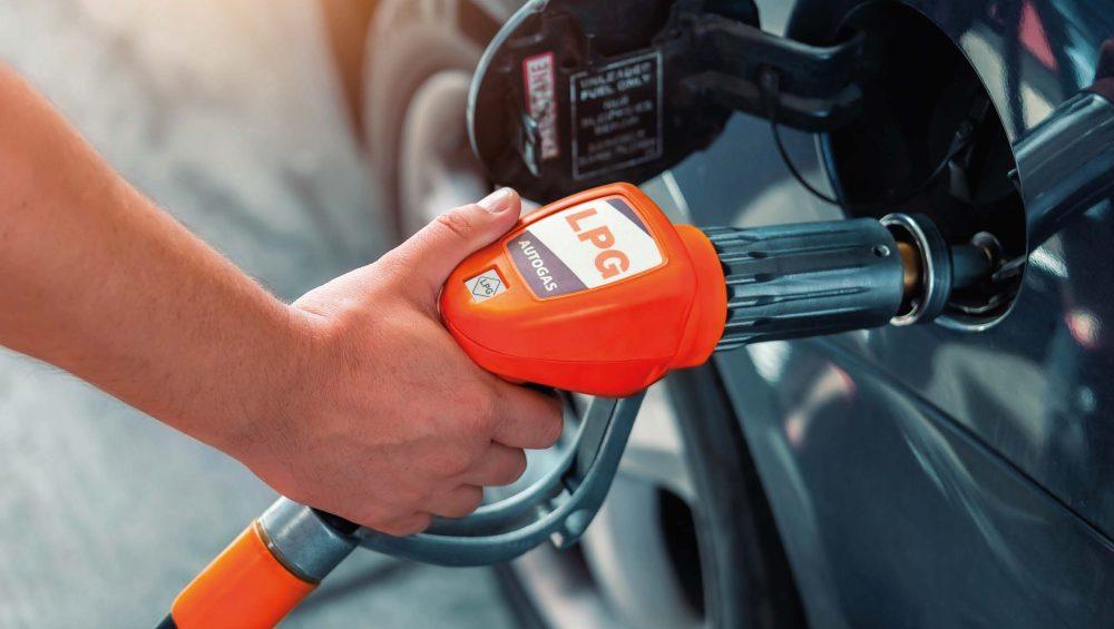 Primer plano de surtidor de gasolina repostando un coche