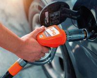 Primer plano de surtidor de gasolina repostando un coche