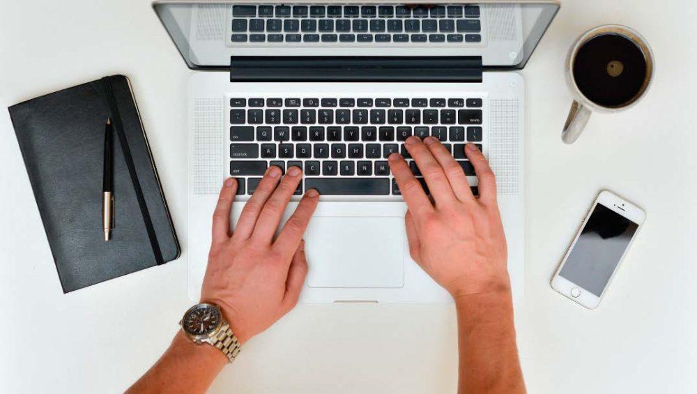 Manos sobre el teclado de un ordenador portátil